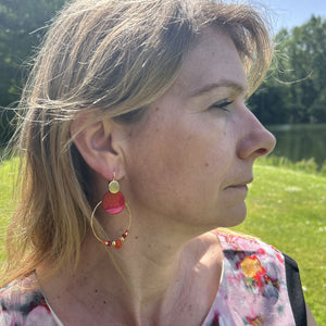 Boucles d'oreilles en nacre rouge portées