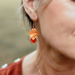 Boucles d’oreilles Danaé en nacre orange et losanges dorés, portées